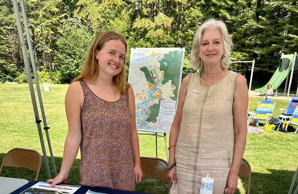 Sam and a colleague at a Howe Sound Biosphere outreach table with maps of the region